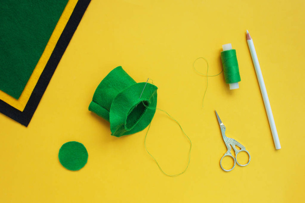 Tutorial how to sew felt leprechaun hat for St. Patrick's day. Concept of DIY sewing art project. Step by step photo instruction. Top view, copy space. Step 4 sew parts - Foto, Imagem