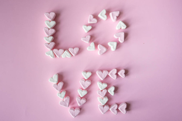 St, concetto di San Valentino con la parola AMORE realizzato con marshmallow a forma di cuore su sfondo rosa
 - Foto, immagini