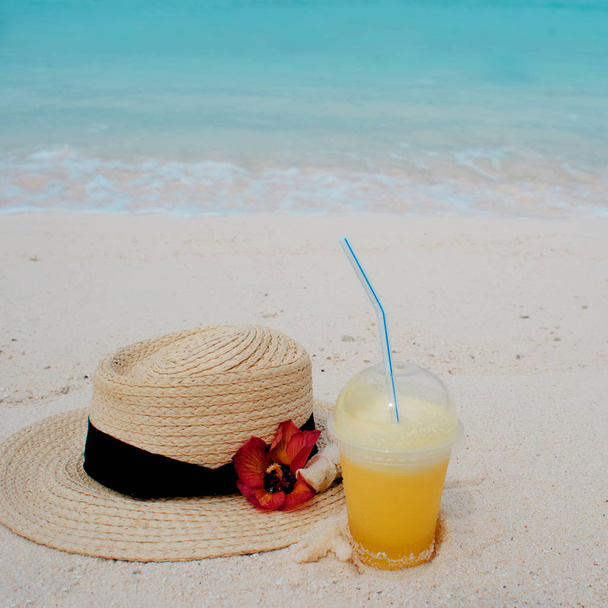 Relájese en una isla tropical, concepto. Protección contra el sol y el calor. Sombrero de paja y jugo de piña
 - Foto, imagen