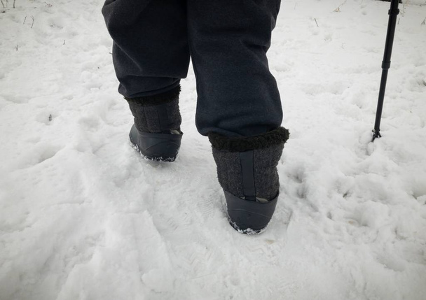 Emberi láb visel éreztem a gumik hóval borított úton gyalogos csizma - Fotó, kép