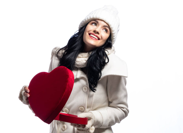 Happy young woman holding a big heart gift box  - Фото, изображение