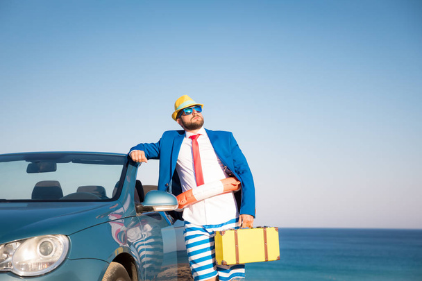 Успешный молодой бизнесмен на пляже. Мужчина, стоящий в классической кабриолете. Летние каникулы и свобода передвижения
 - Фото, изображение