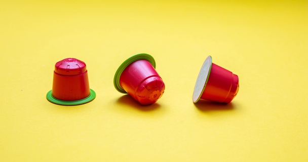 Coffee capsules compostable. Red espresso pods, eco friendly, aluminum free with green ring on yellow background - Foto, Imagem