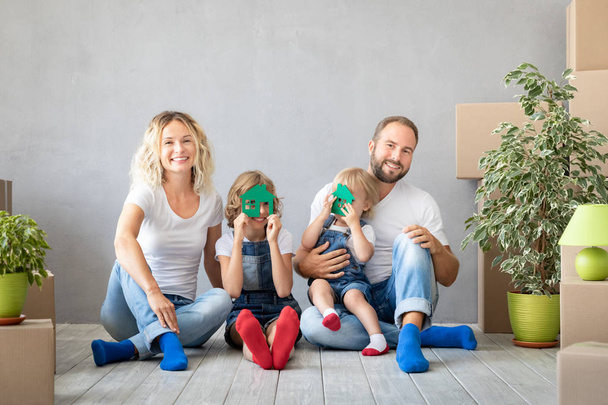 Happy family with two kids playing in new home. Father, mother and children having fun together. Moving house day and real estate concept - Foto, Imagem