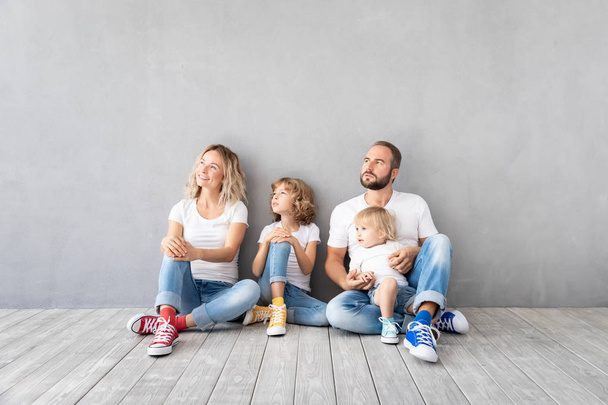 Happy family with two kids playing in new home. Father, mother and children having fun together. Moving house day and real estate concept - Foto, Imagen