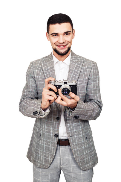 a felvásárló a régi film kamera. elegáns fiatal szakállas fickó egy kamera a kezében - Fotó, kép