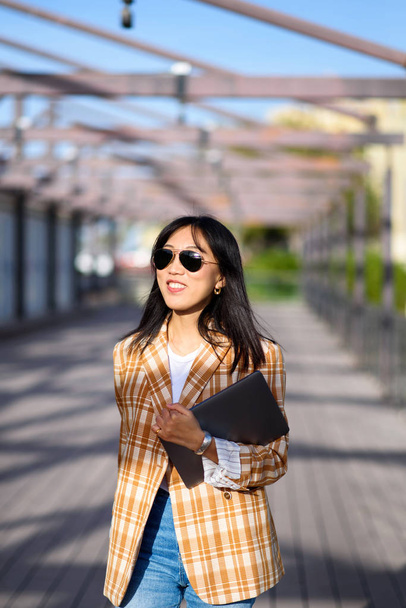 Fashionable Asian woman with laptop outdoors portrait - Fotó, kép