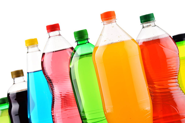 Plastic flessen van diverse koolzuurhoudende frisdranken op witte achtergrond - Foto, afbeelding