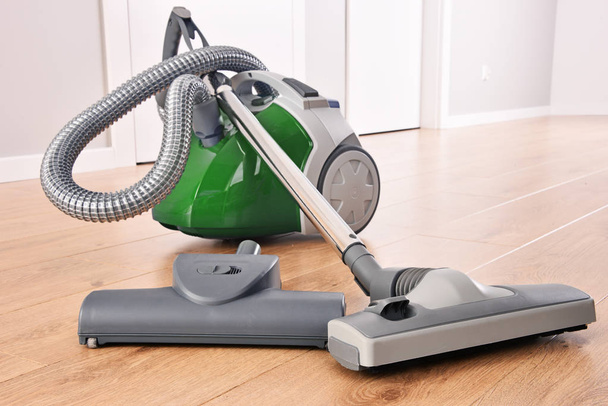 Canister vacuum cleaner for home use on the floor panels in the apartment. - Photo, Image