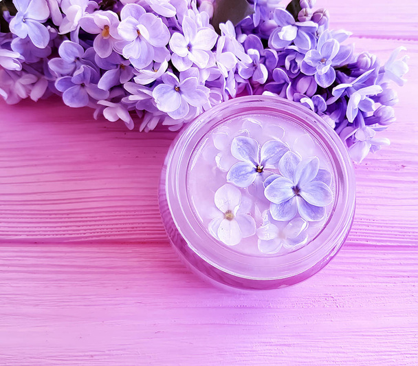 cosmetic cream, lilac flower on wooden background - Photo, Image
