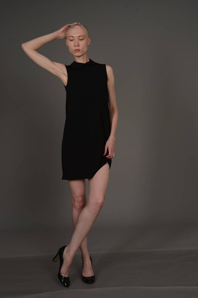 bald girl posing in Studio in black dress - Fotó, kép