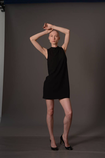 bald girl posing in Studio in black dress - Foto, immagini