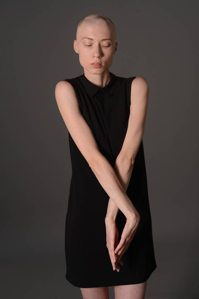 bald girl posing in Studio in black dress - Photo, Image