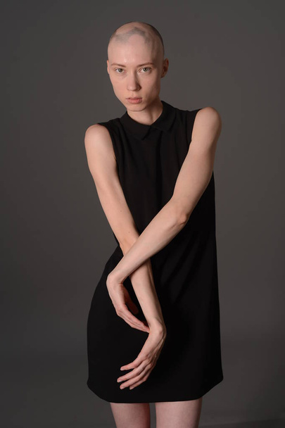 bald girl posing in Studio in black dress - Fotoğraf, Görsel