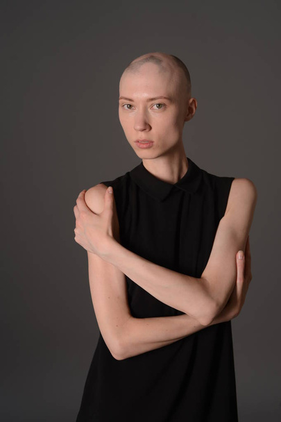 bald girl posing in Studio in black dress - Фото, зображення