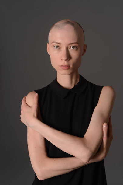bald girl posing in Studio in black dress - Zdjęcie, obraz