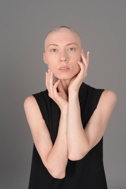 bald girl posing in Studio in black dress - Фото, зображення