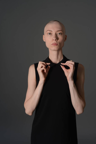 bald girl posing in Studio in black dress - Foto, Bild