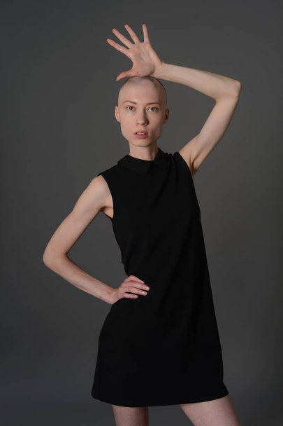 bald girl posing in Studio in black dress - 写真・画像