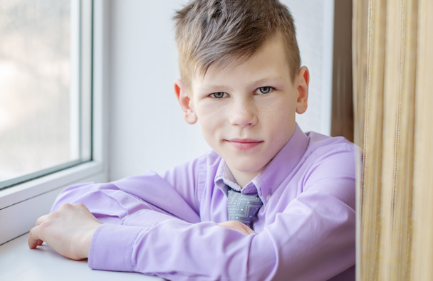 Portrét roztomilé dospívající chlapec v okně - Fotografie, Obrázek