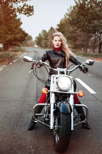 Prachtige biker vrouw buiten met motorfiets.  - Foto, afbeelding