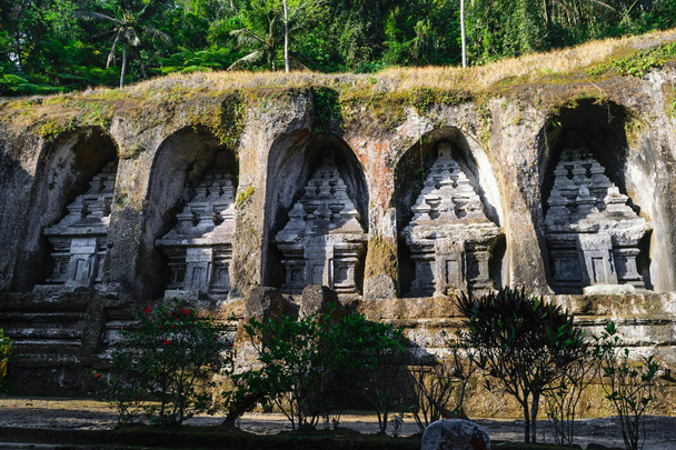 Gunung Kawi chrámového komplexu vytesané kamenné útesy s džunglí na útesu v Bali, Indonésie - Fotografie, Obrázek