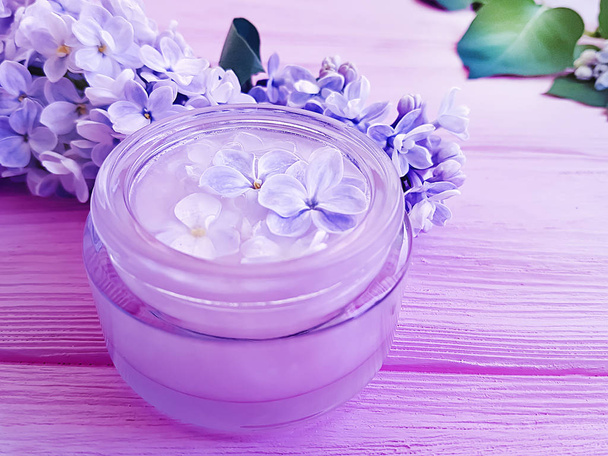 cosmetische crème, Lila bloem op houten achtergrond - Foto, afbeelding