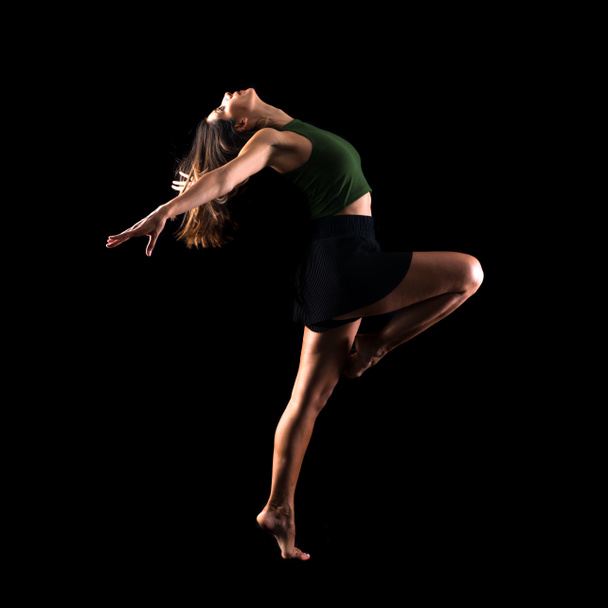 Молода дівчина танцює і стрибає в студії на ізольованому фоні
 - Фото, зображення
