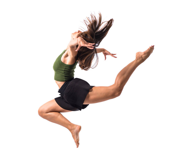 Nuori tyttö tanssii ja hyppii studiossa eristetyllä taustalla
 - Valokuva, kuva