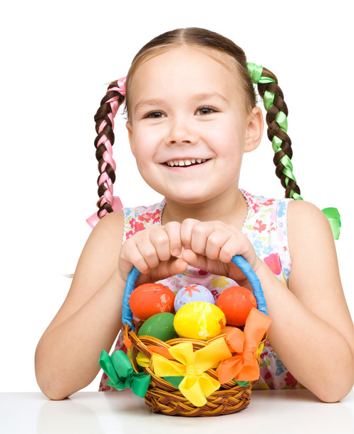 Little girl with basket full of colorful eggs - Fotoğraf, Görsel