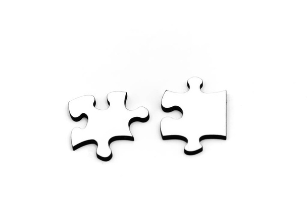 Two connected jigsaw puzzle pieces on white background. - 写真・画像
