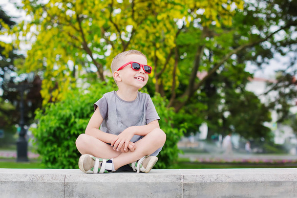Gelukkig jongetje met bril in het park op een wandeling - Foto, afbeelding
