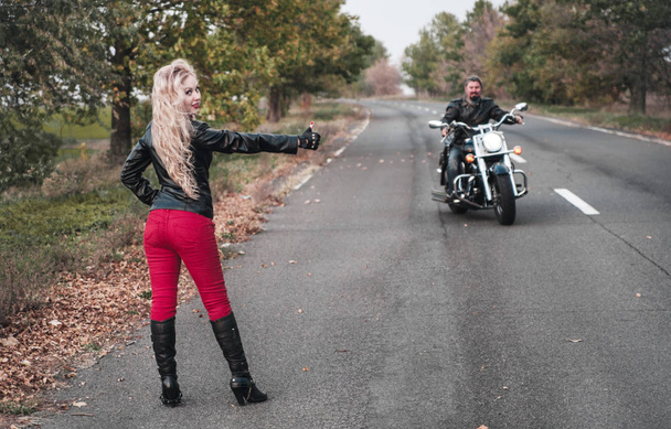 Couple bikers with motorcycle on the road. - Фото, изображение