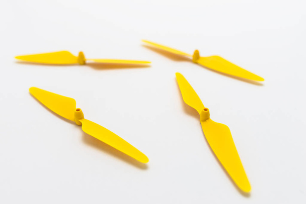 Κίτρινο, πλαστικές προπέλες για ένα τετράγωνο ελικόπτερο drone, που απομονώνονται σε λευκό φόντο.  - Φωτογραφία, εικόνα