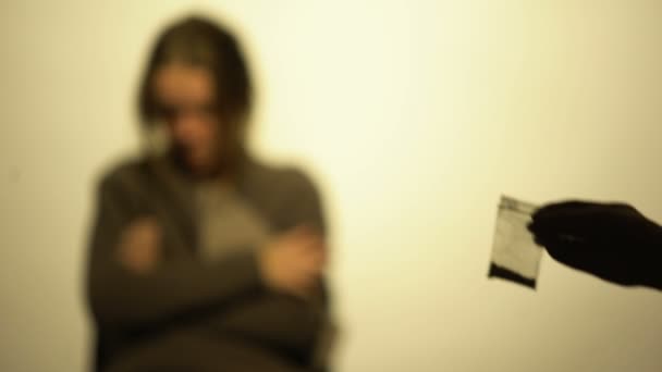 Hand zeigt Frau mit Entzugserscheinungen Päckchen mit Puder, Reha - Filmmaterial, Video
