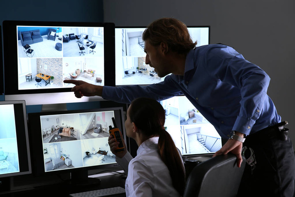 Guardas de segurança monitorando câmeras de CCTV modernas na sala de vigilância - Foto, Imagem
