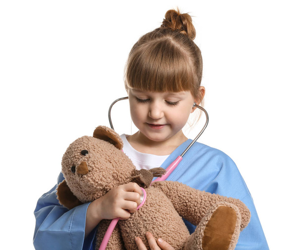 Portrait of cute little doctor with stethoscope and teddy bear on white background - Φωτογραφία, εικόνα
