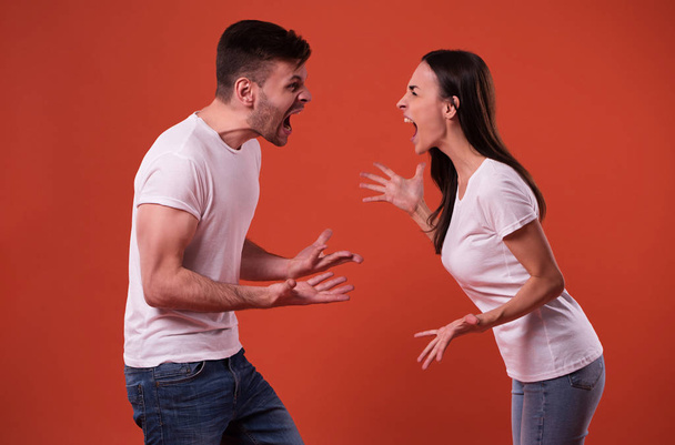 Side view photo of young angry and shouting couple in white t-shirts - Фото, изображение