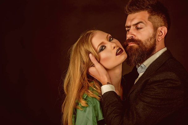 Keeping romance alive. Intimate couple in fashion clothing. Fashion style and hair care. Style icons. They both love fashion. Couple in love. Bearded man hug woman with long hair, copy space - Фото, зображення
