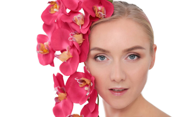 Young beauty woman with flower near face. - Valokuva, kuva