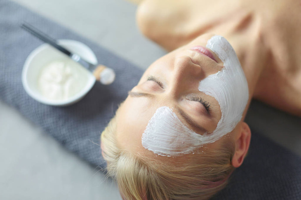 Face mask.Beautiful young girl at spa ,cosmetician woman applying facial mask. - Photo, Image