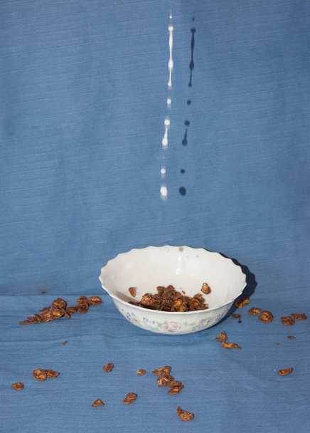 Milch fällt auf eine Schüssel mit Schokozerealien - Foto, Bild