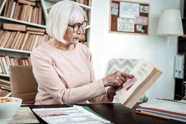 Concentrated senior female person reading her book - Foto, Imagem