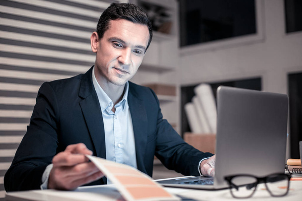 Smart handsome businessman sitting at the laptop - Photo, image