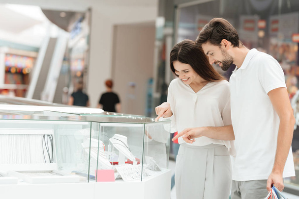 Man and woman are looking at jewelry in kiosk in shopping mall. - Foto, Imagem