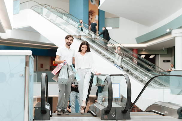Muž a žena v shopping mall. Pár se děje eskalátor. - Fotografie, Obrázek