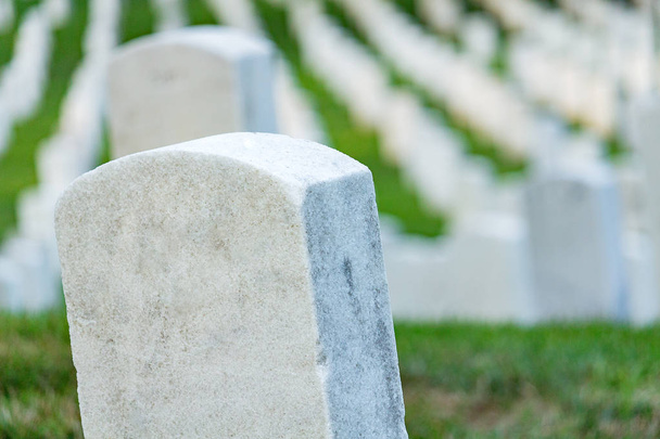 Grave stones on a peaceful cemetery, selective focus on a front stone. - Photo, Image