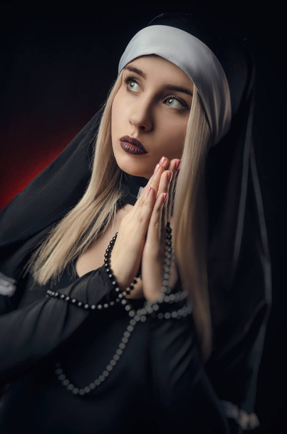 Portrait artistique d'une religieuse novice en prière profonde avec chapelet
 - Photo, image