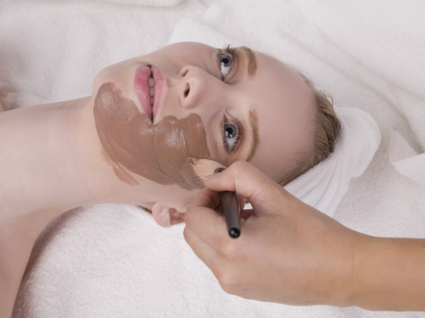 een vrouw met chocolade gezichtsmasker - Foto, afbeelding