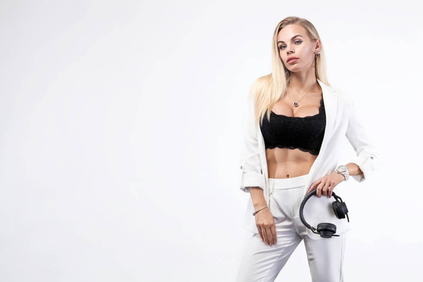 Beautiful sexy blonde DJ woman on white background in studio wearing headphones. Album cover. - Foto, Bild